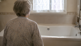 Une dame agée face à une baignoire