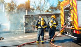 Des pompiers en intervention sur un bus en feu.