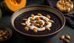 Soupe de potiron noir au charbon végétal, crème d'ail rôti et graines de courge caramélisées